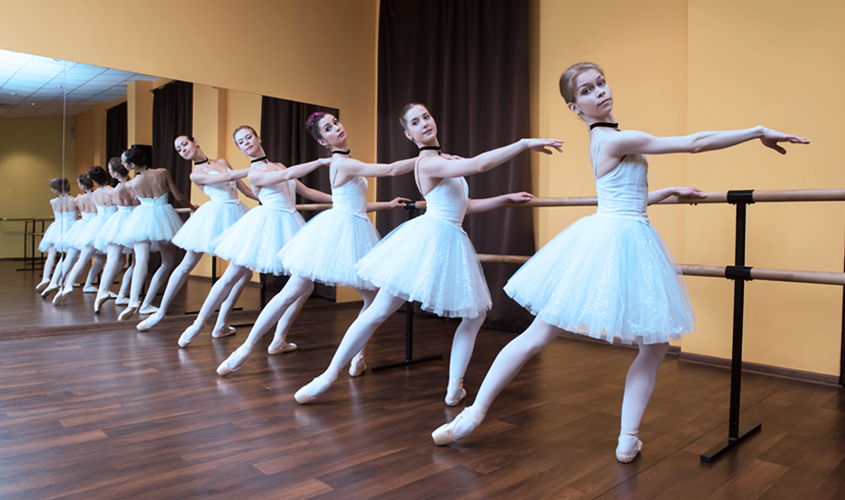 Costumed teen dancers are practicing their routine.