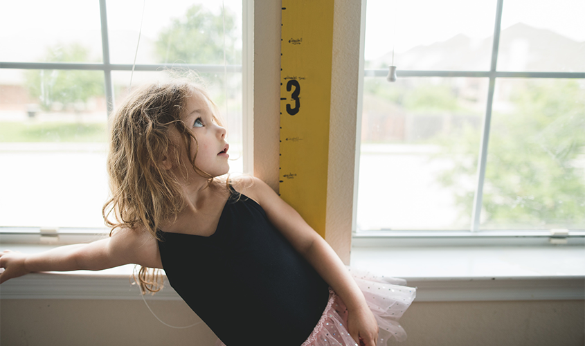 A dance student is measuring her growth.