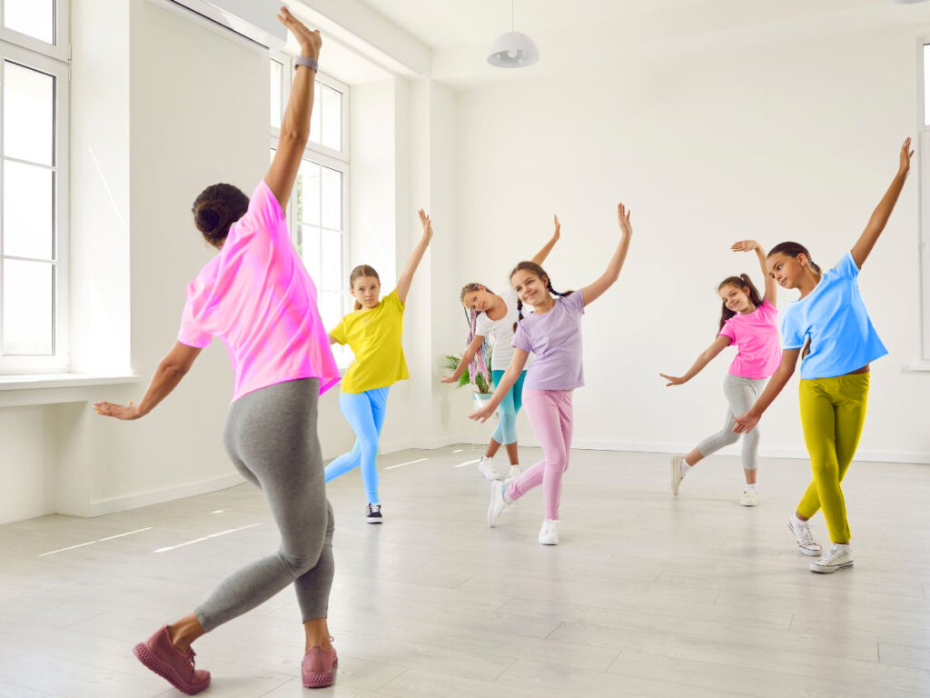 A dance teacher leads students in an exercise