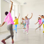 A dance teacher leads students in an exercise