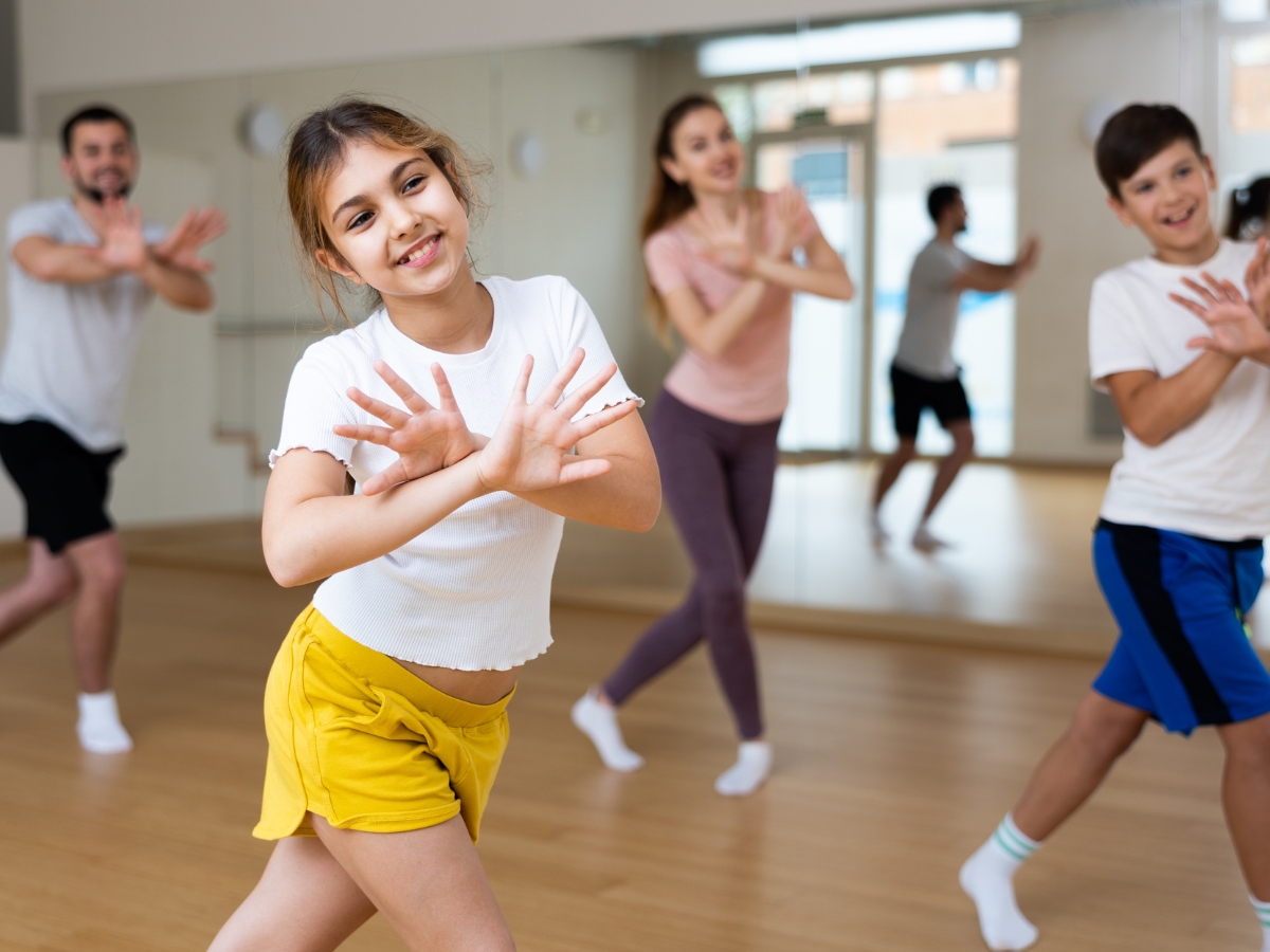 2 Dancers work on their routine as their instructors lead in the background